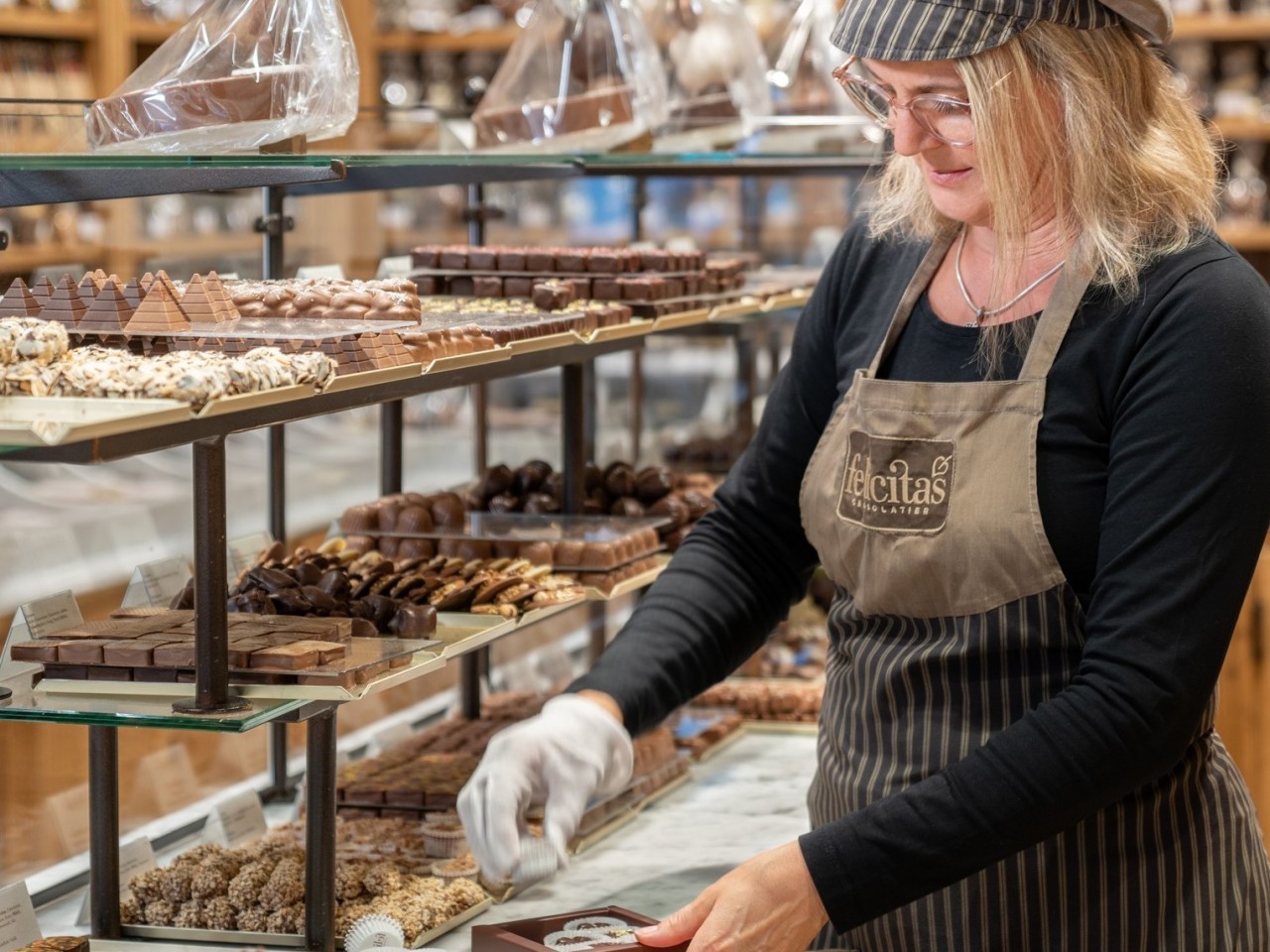 Verkäuferin verpackt Pralinen in der Confiserie Felicitas, © Confiserie Felicitas