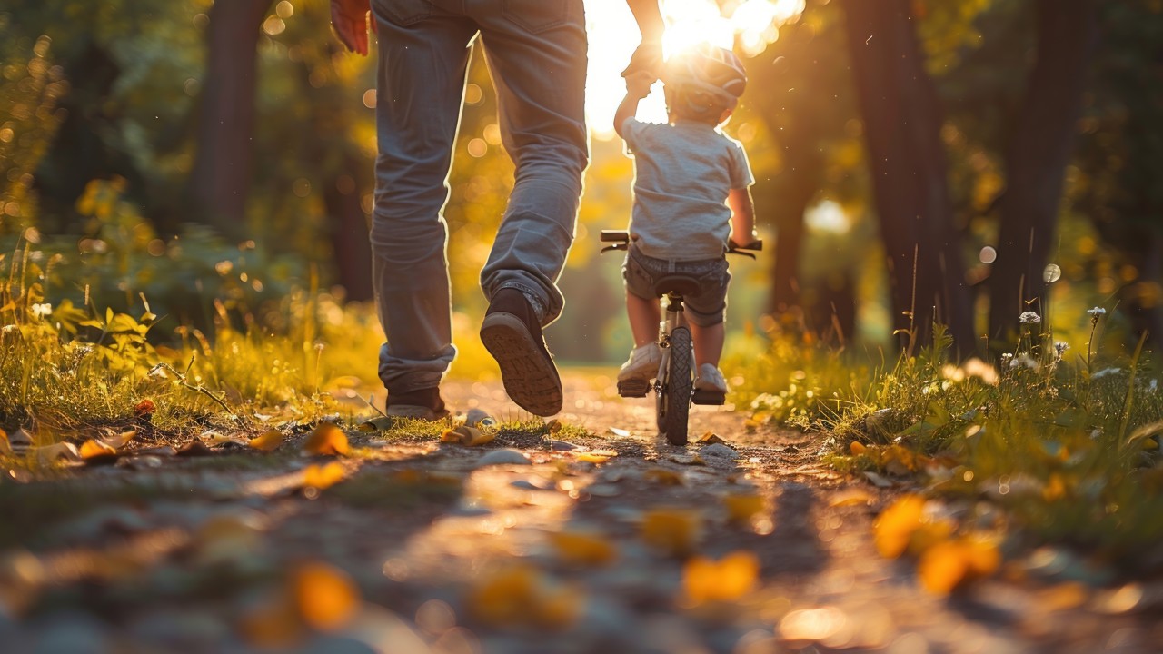 AdobeStock_832008740 arzaq, © Mann hält Kind, das Radfahren lernt